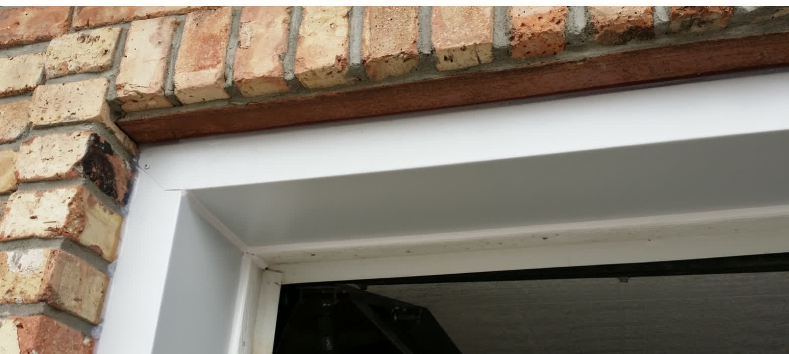 Brick Lintel — after: capped in custom-bent aluminum, no more repainting (Calgary)