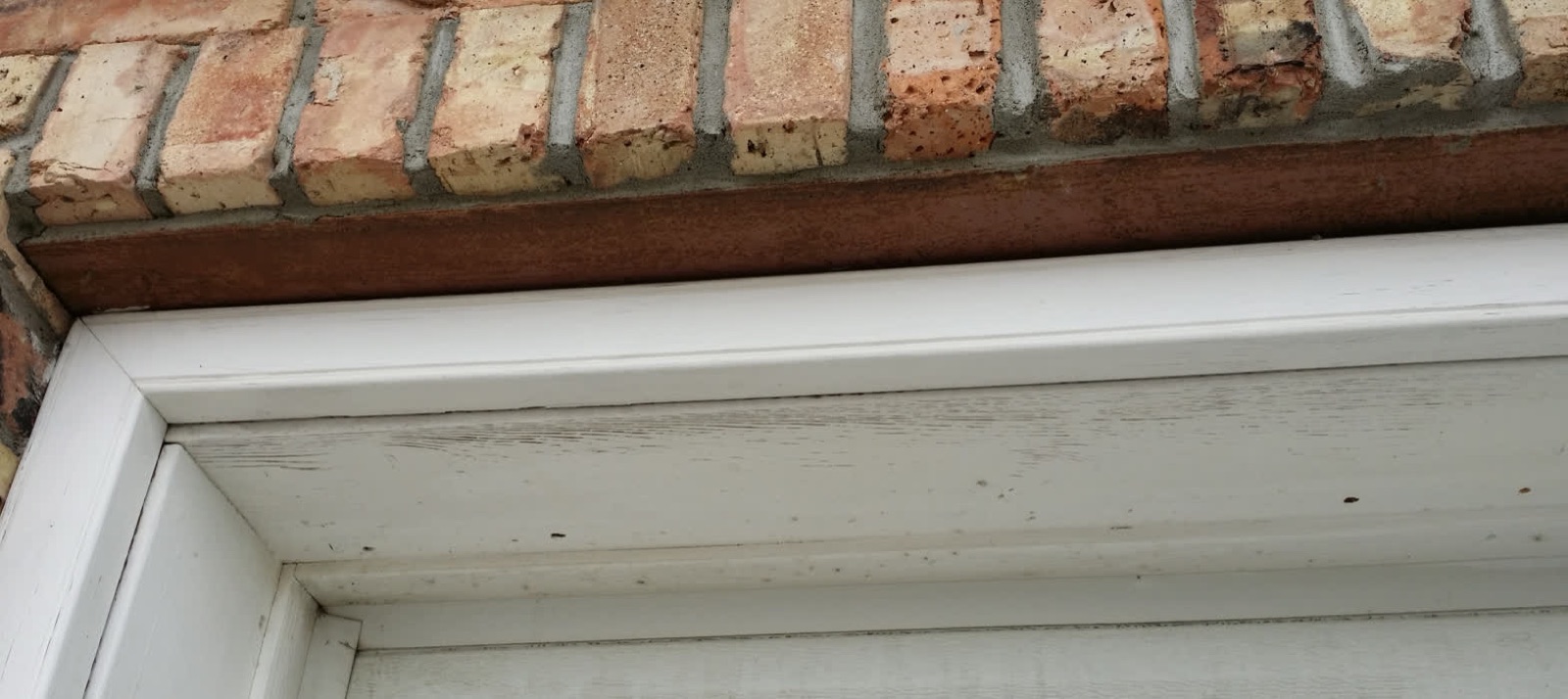 Brick Lintel — before: worn painted wood trim (Calgary)